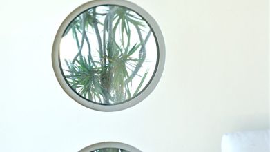 Bathroom with round windows facing plants | passive solar design | Dean Larkin Design