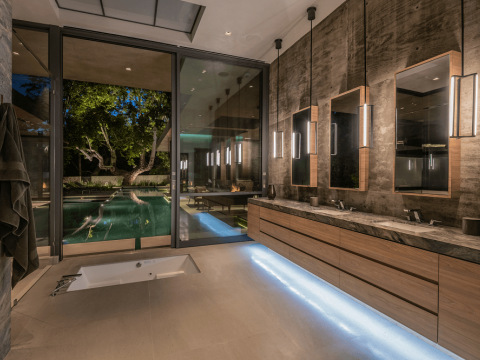 Latimer | Primary bathroom with under cabinet lighting and doors to pool | Dean Larkin Design