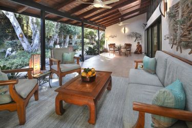 View from loggia into courtyard includes couch, chairs and a table | River Lane Architecture Project | Dean Larkin Design