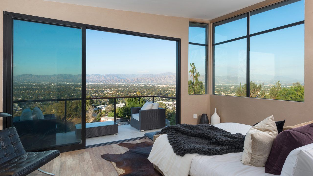 bedroom with wall length glass door and large windows | Light in Contemporary Architecture | Dean Larkin Design talks about the way architects use light