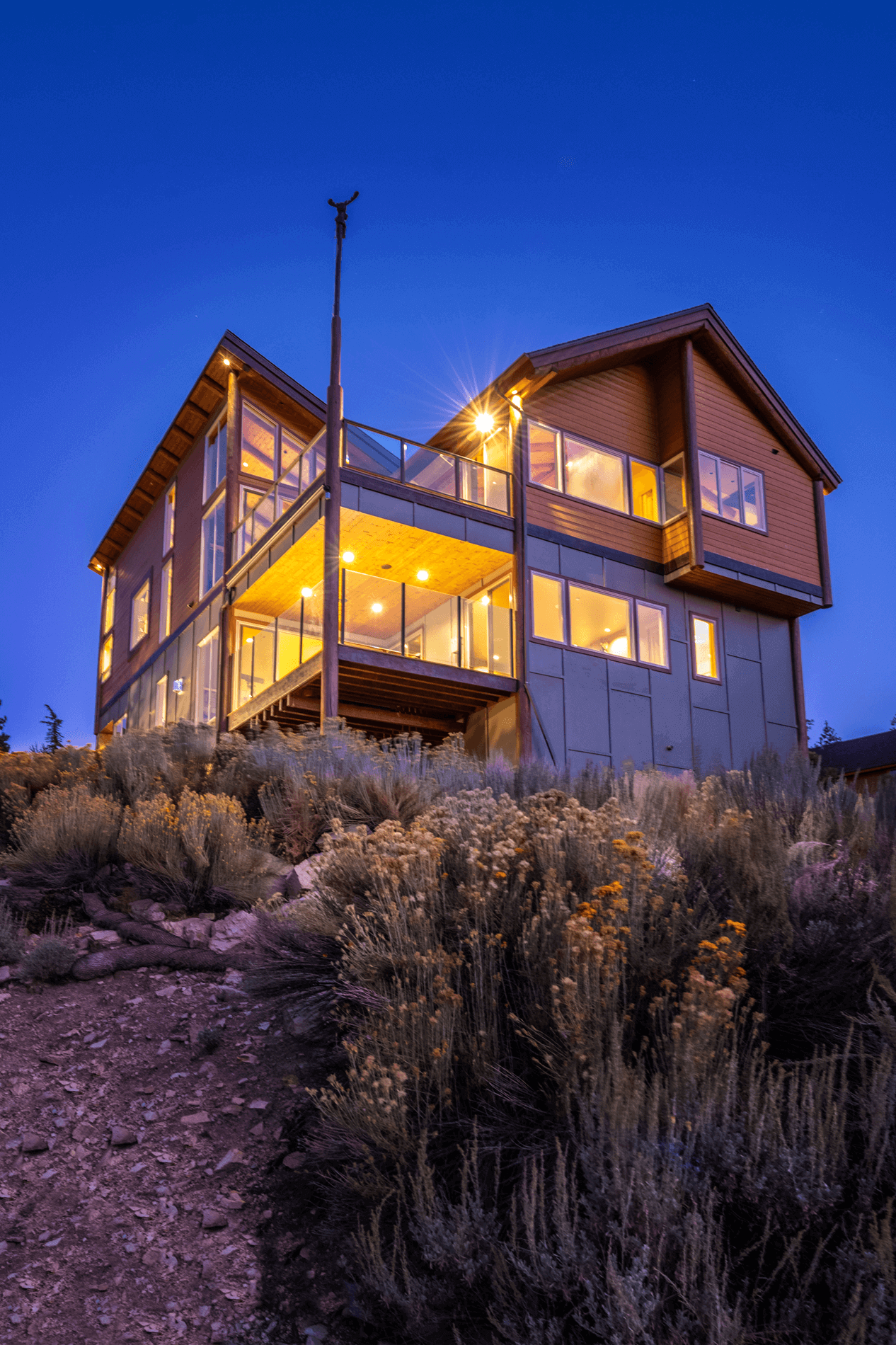 Eagle Lake Project - Early evening view from bottom of slope up to house and decks - Dean Larkin Design