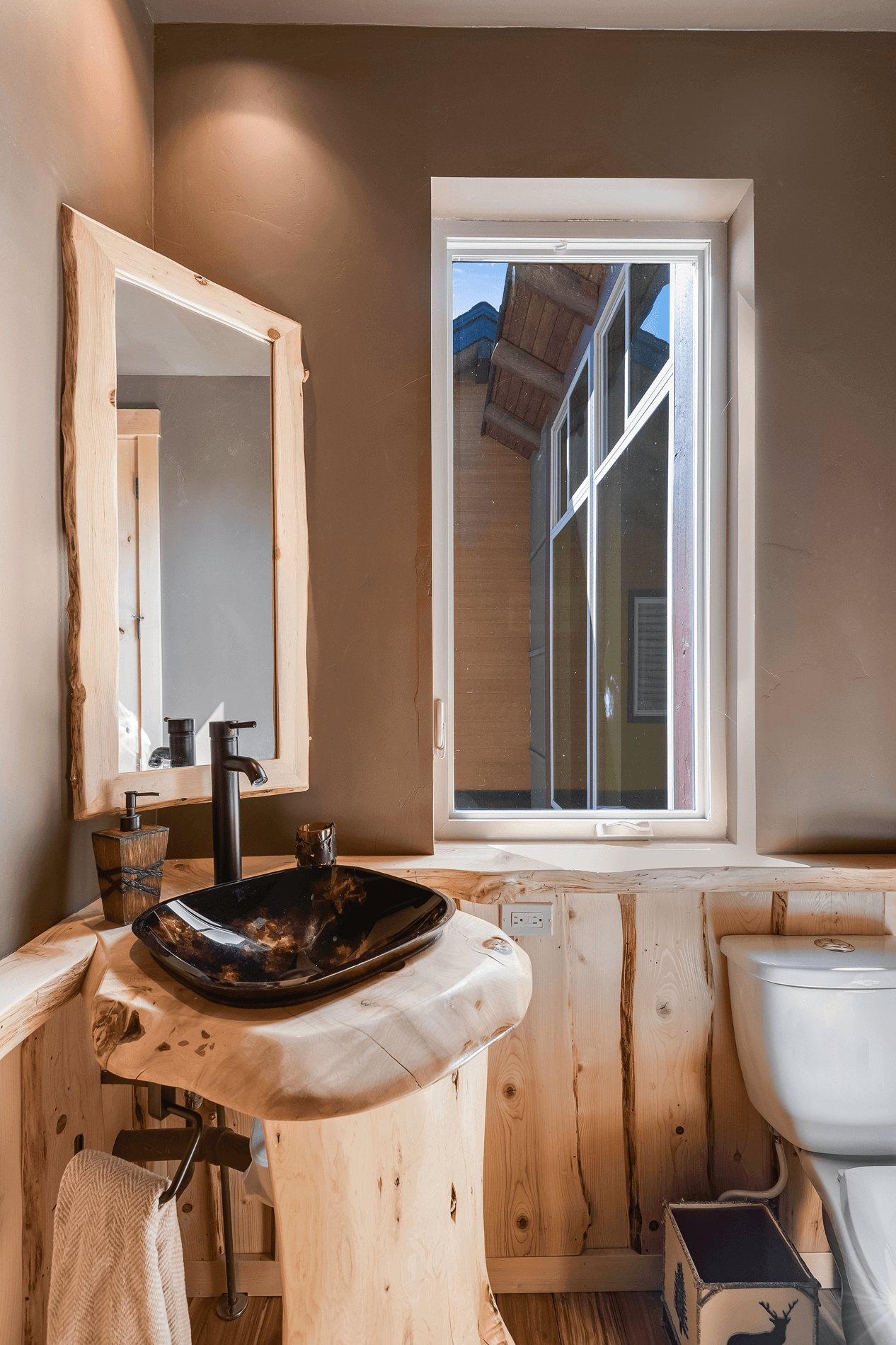 Eagle Lake Project - bathroom with carved wooden accents and pedestal with brown toned bowl sink - Dean Larkin Design