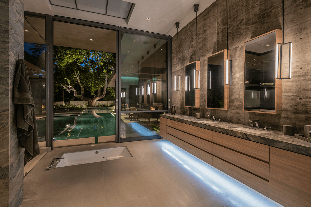 Latimer | Primary bathroom with under cabinet lighting and doors to pool | Dean Larkin Design Luxury Residential Architects in the Los Angeles Area answer FAQs