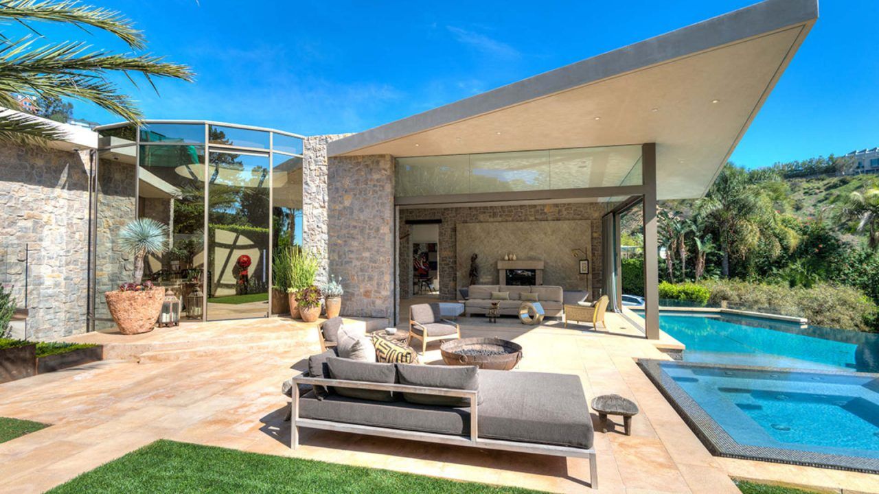View of rear of home with glass wall, outdoor patio and pool | Contemporary Architecture Design | Dean Larkin Design