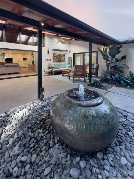 view of courtyard with a spherical black fountain into loggia | River Lane Project | Dean Larkin Design