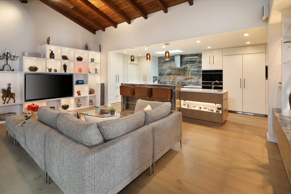 Whole room view across Cantoni couch into kitchen with pendant lights, and including the entertainment center | River Lane Project | Dean Larkin Design