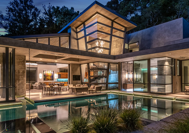 view into Latimer house at night, from the outdoor living space and pool - Dean Larkin Luxury Residential Architects in the Los Angeles Area Answer FAQs